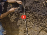 image of a farmer looking at the soil and a red video play button